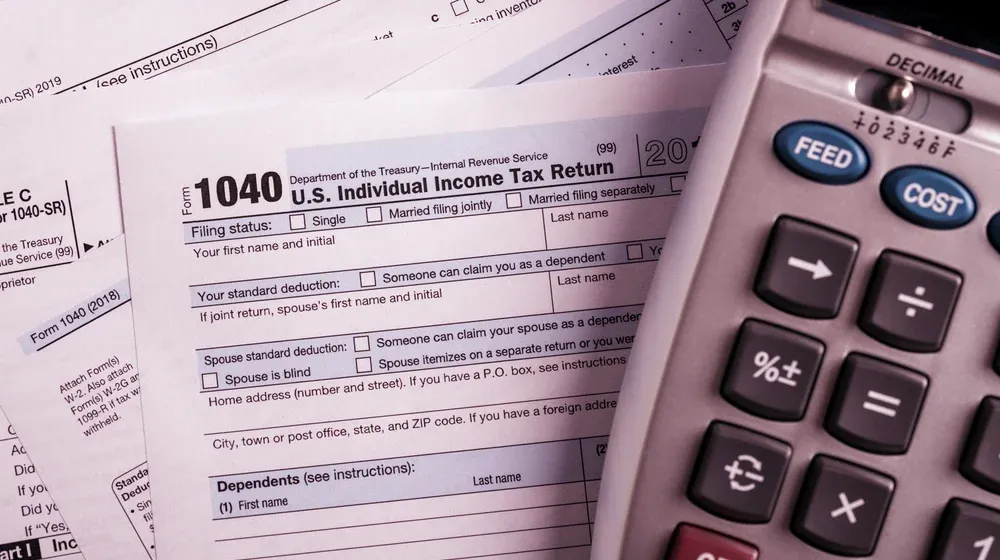 Formularios 1040 del IRS junto a una calculadora.